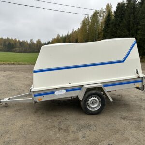 Traveller Retkeilijä perävaunu, yksakselinen kuomullinen kärry seisoo soratiellä syksyisessä maisemassa.