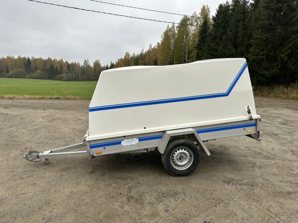 Traveller Retkeilijä perävaunu, yksakselinen kuomullinen kärry seisoo soratiellä syksyisessä maisemassa.